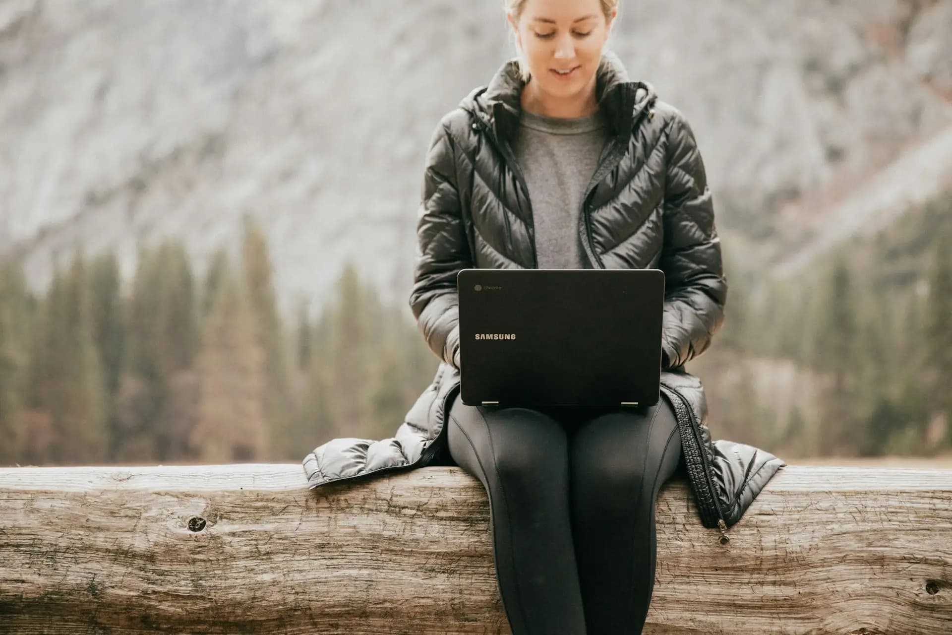 Woman in nature looking on her laptop